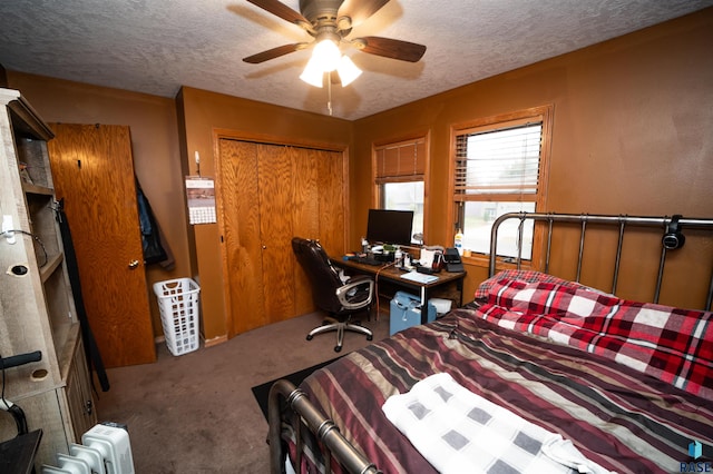 bedroom featuring a ceiling fan, a closet, carpet floors, and a textured ceiling