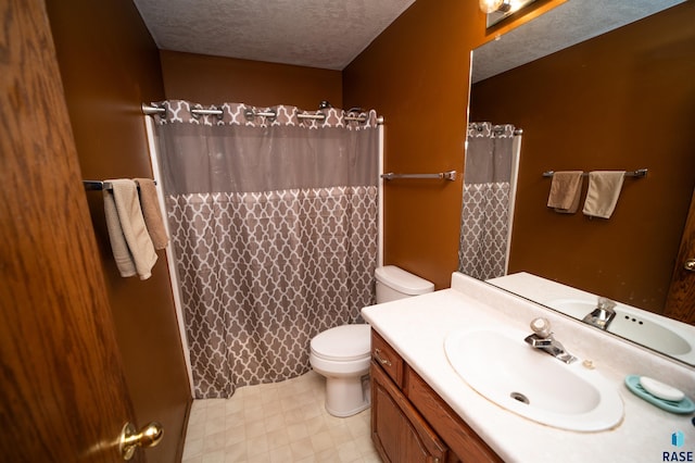 bathroom with vanity, toilet, a shower with curtain, and a textured ceiling