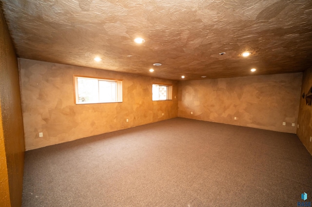 basement featuring carpet flooring, recessed lighting, and a textured ceiling