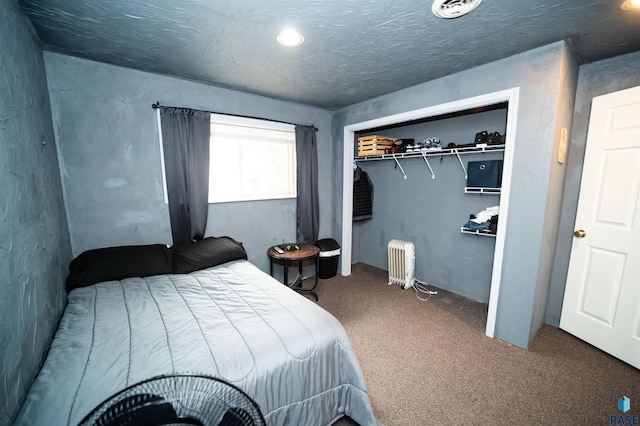 carpeted bedroom with a closet, radiator, and a textured ceiling