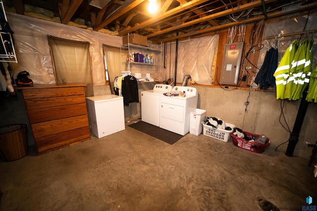 unfinished basement with electric panel, fridge, and independent washer and dryer