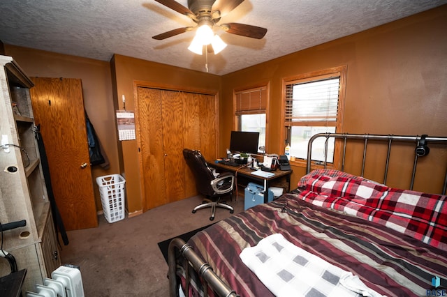 bedroom featuring a closet, carpet flooring, a textured ceiling, and ceiling fan