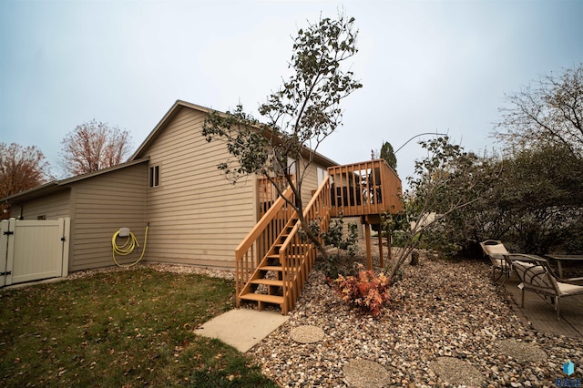 back of property with a gate, a patio, fence, a wooden deck, and stairs