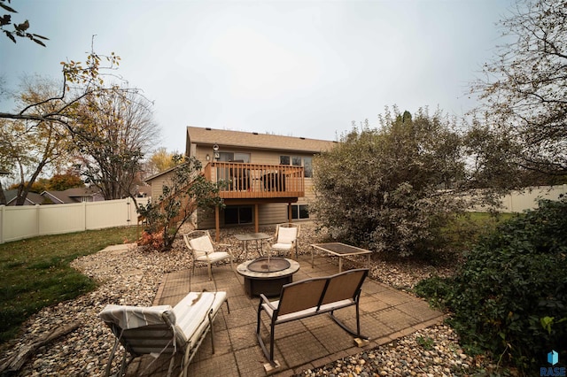 view of patio featuring a deck, a fire pit, and fence