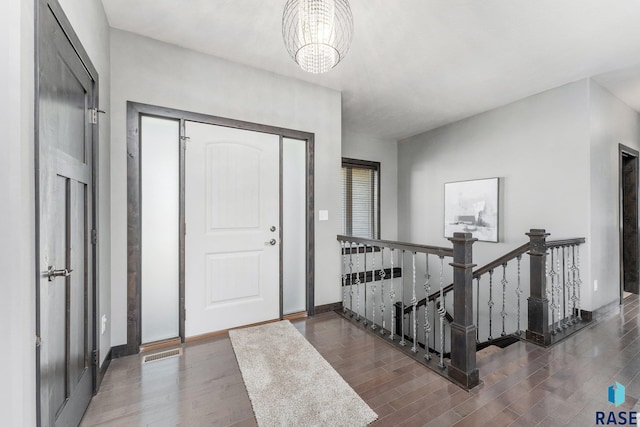 foyer featuring dark hardwood / wood-style flooring and a notable chandelier