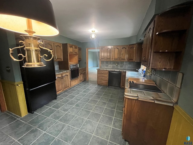 kitchen with decorative backsplash, black appliances, sink, and dark tile patterned floors