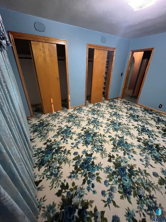 bedroom with a textured ceiling and two closets