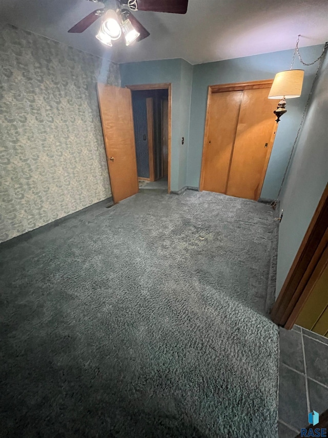 interior space featuring ceiling fan and dark colored carpet