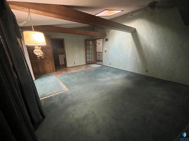 unfurnished room featuring ceiling fan and beamed ceiling