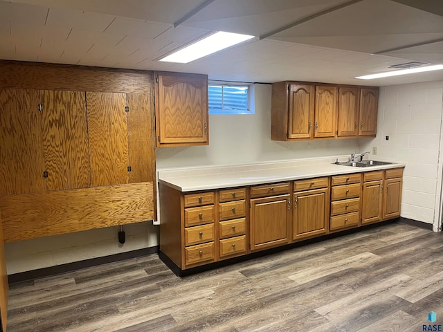 kitchen featuring dark wood-type flooring, a drop ceiling, and sink