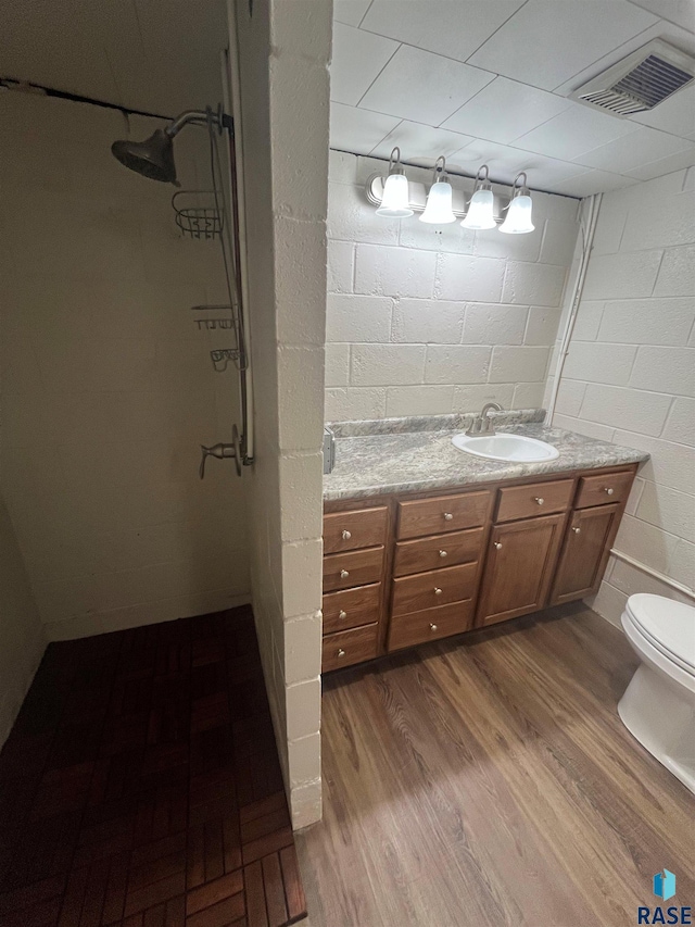 bathroom featuring walk in shower, vanity, toilet, and hardwood / wood-style flooring