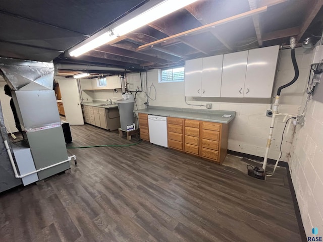 basement with dark hardwood / wood-style floors, heating unit, and sink