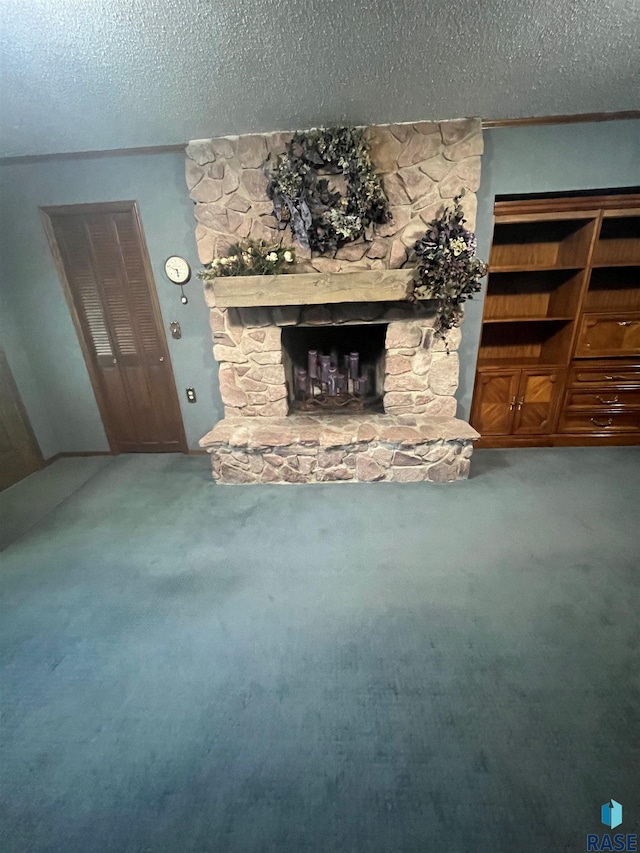 unfurnished living room with a stone fireplace, a textured ceiling, and carpet flooring