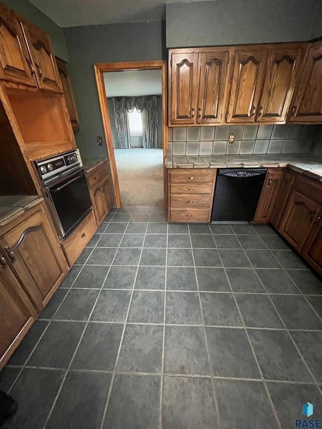 kitchen with black appliances and tasteful backsplash