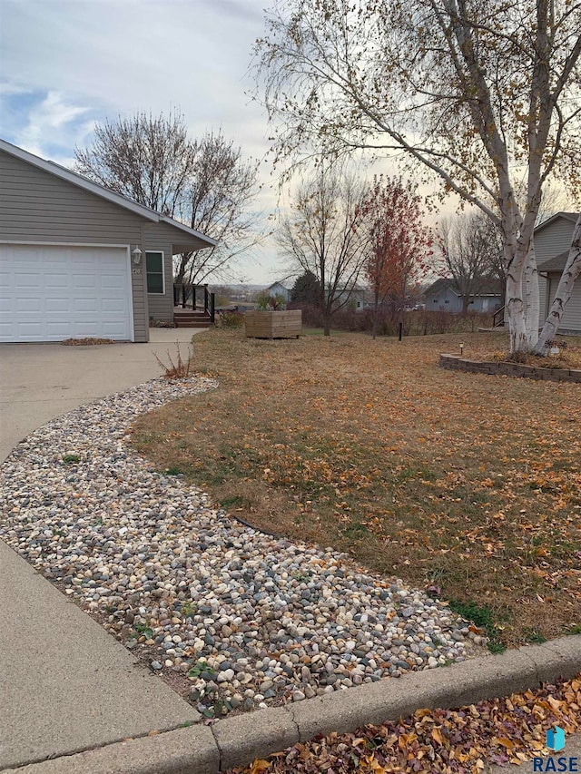 yard at dusk featuring a garage