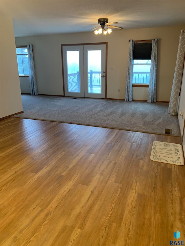 spare room with french doors, light hardwood / wood-style floors, a wealth of natural light, and ceiling fan