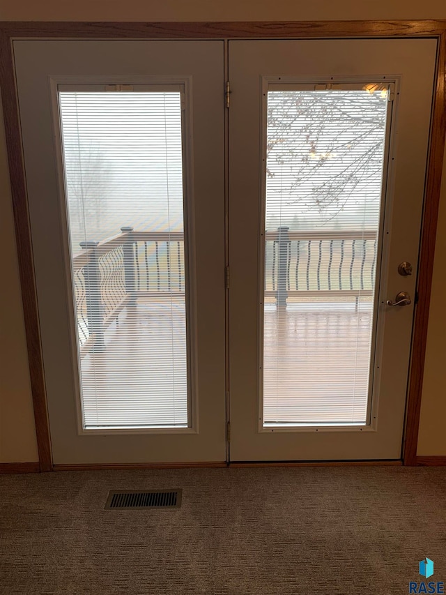 doorway to outside with carpet floors