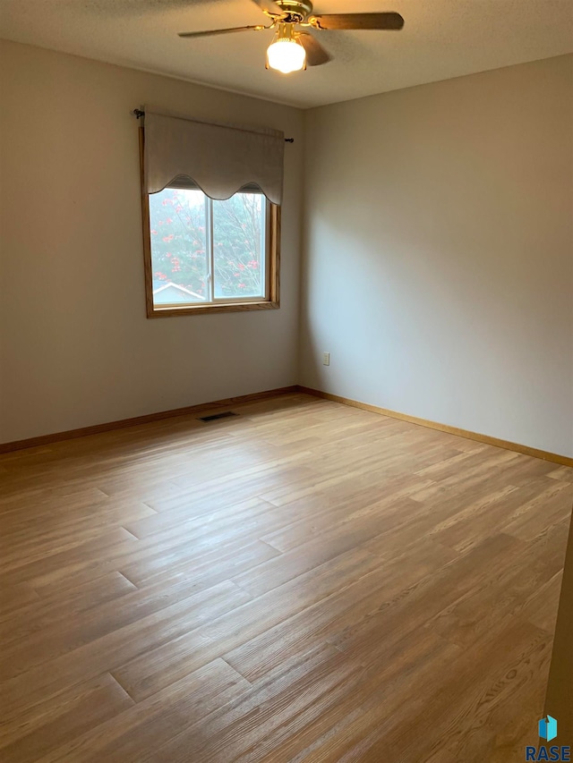 spare room with a textured ceiling, light hardwood / wood-style flooring, and ceiling fan