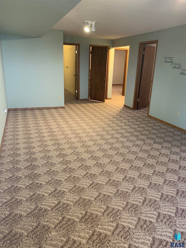 empty room featuring a textured ceiling and light colored carpet