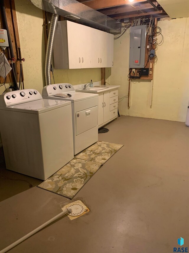 clothes washing area featuring electric panel, washer and clothes dryer, cabinets, and sink