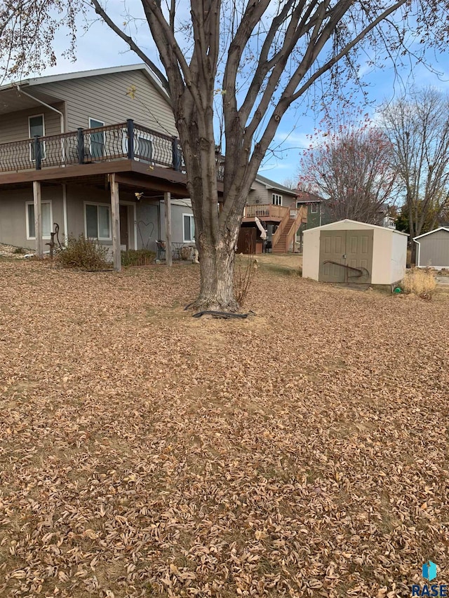 back of house with a storage unit and a wooden deck