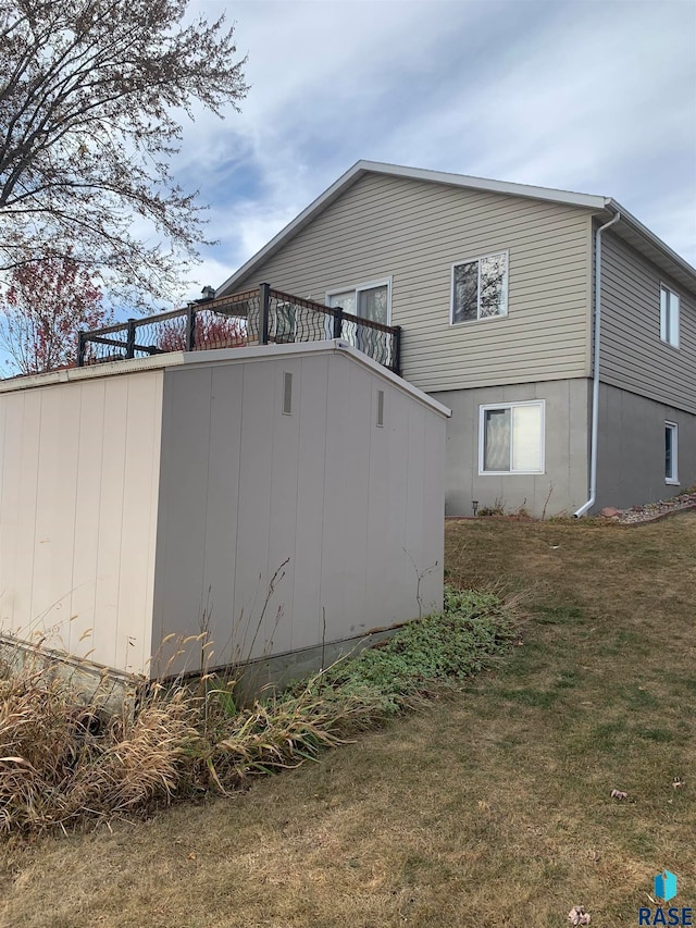 view of side of property with a storage shed and a yard