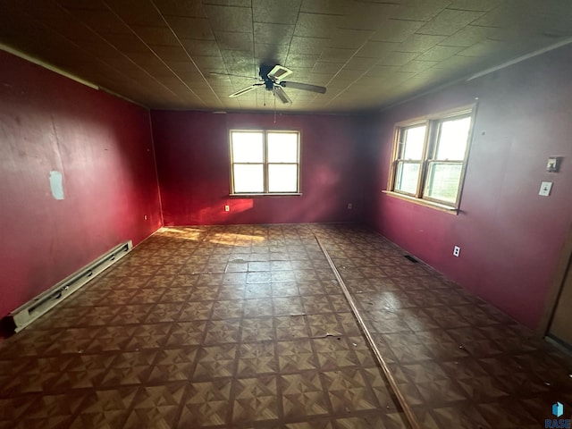 unfurnished room featuring ceiling fan, plenty of natural light, and a baseboard heating unit