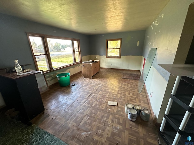 interior space with a wealth of natural light and dark parquet flooring