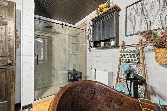 bathroom featuring wood walls and walk in shower