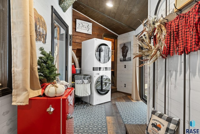 laundry area featuring wood ceiling, stacked washer / dryer, wooden walls, and dark wood-type flooring