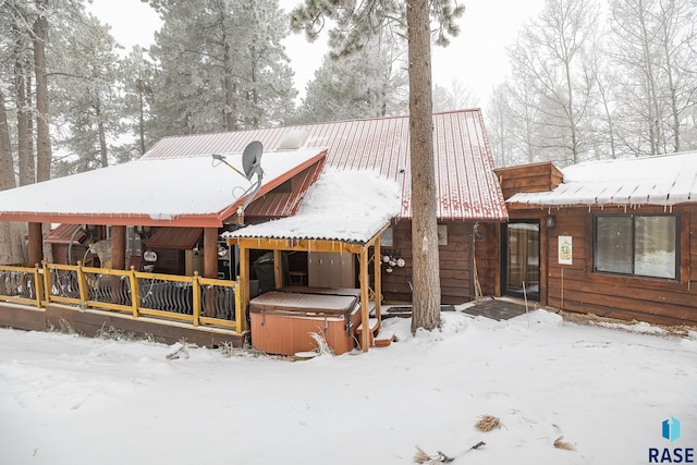 snow covered property with a hot tub