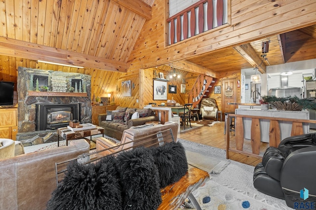 living room with wood walls, high vaulted ceiling, hardwood / wood-style flooring, beam ceiling, and wood ceiling