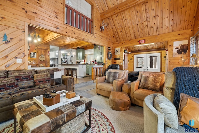 living room with beam ceiling, wooden ceiling, high vaulted ceiling, wood walls, and a chandelier