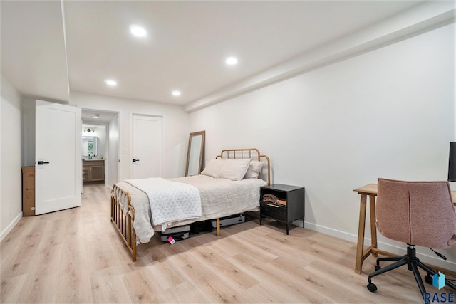 bedroom with ensuite bath and light hardwood / wood-style flooring