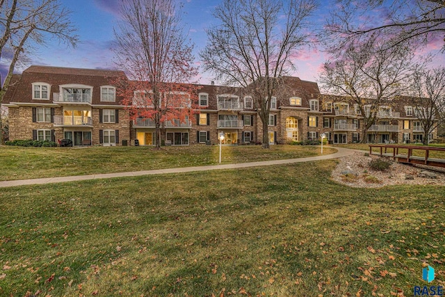 exterior space with a balcony and a lawn