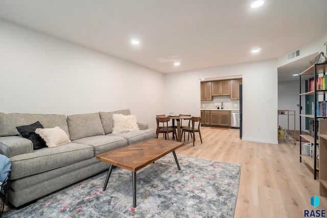 living room with sink and light hardwood / wood-style flooring