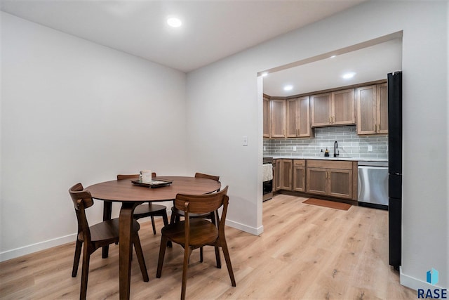 dining space with sink and light hardwood / wood-style flooring