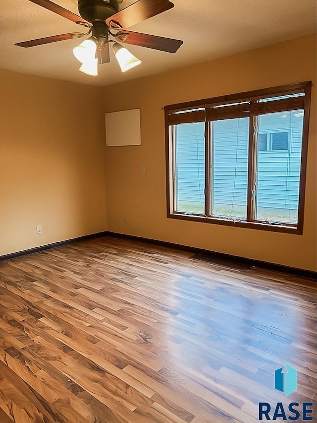 323 W Lincoln St, Luverne, MN 56156 - unfurnished room featuring wood finished floors, baseboards, and a ceiling fan