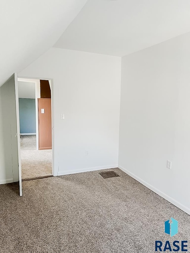 323 W Lincoln St, Luverne, MN 56156 - bonus room with carpet floors, vaulted ceiling, and baseboards