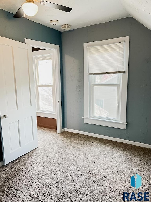 323 W Lincoln St, Luverne, MN 56156 - unfurnished bedroom with carpet floors, vaulted ceiling, baseboards, and a ceiling fan