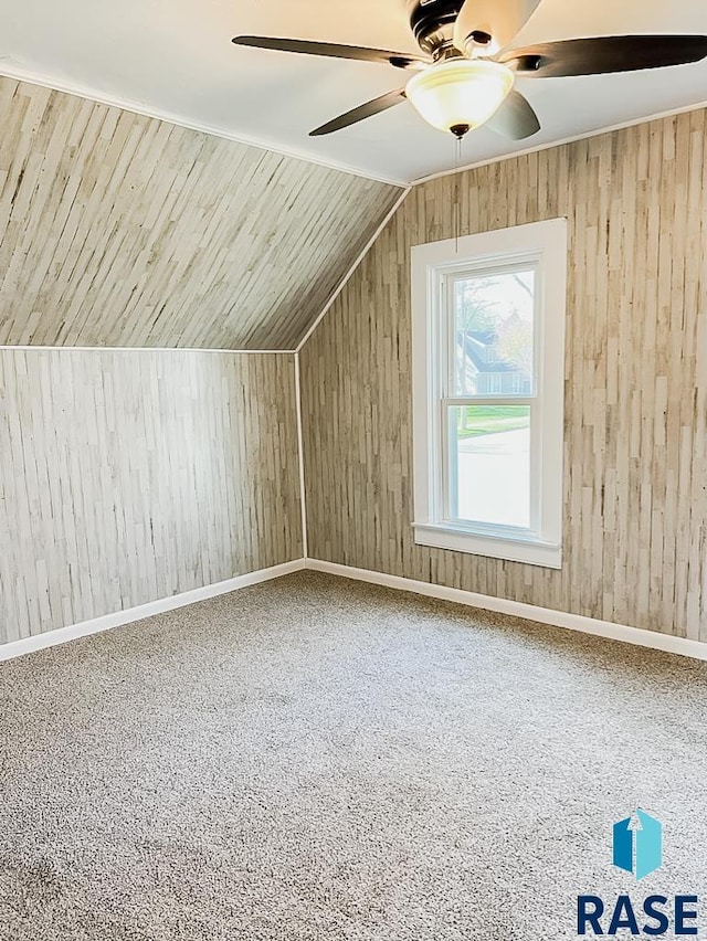 323 W Lincoln St, Luverne, MN 56156 - bonus room featuring a ceiling fan, vaulted ceiling, wooden walls, carpet, and baseboards