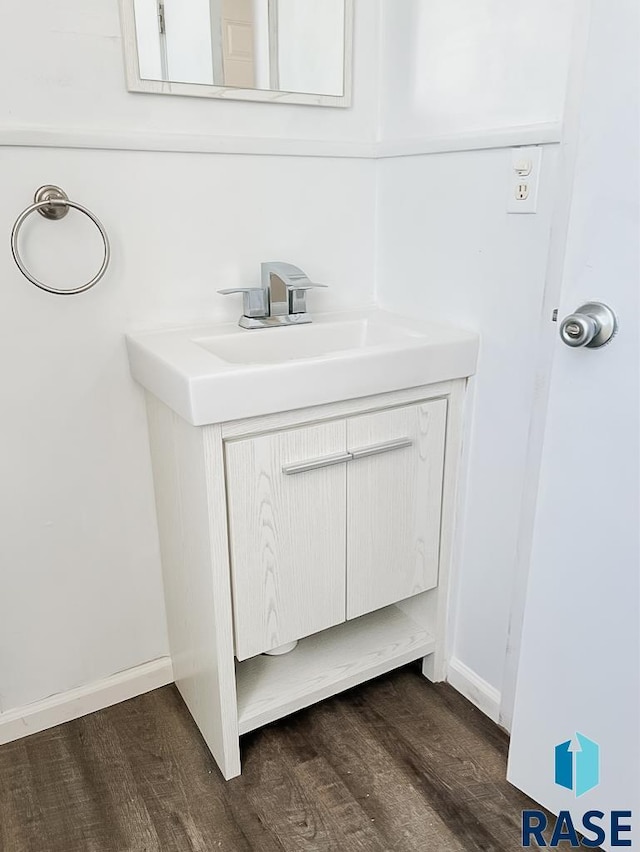 323 W Lincoln St, Luverne, MN 56156 - bathroom view of wood finished floors, vanity, and baseboards