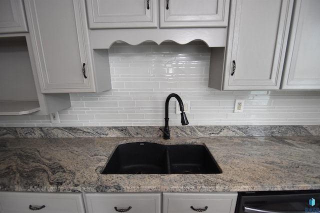 kitchen featuring white cabinetry, sink, backsplash, and black dishwasher