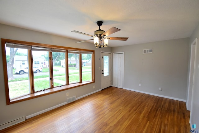 empty room with ceiling fan and light hardwood / wood-style floors