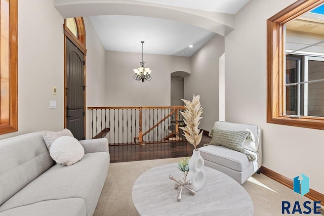 carpeted living room featuring an inviting chandelier