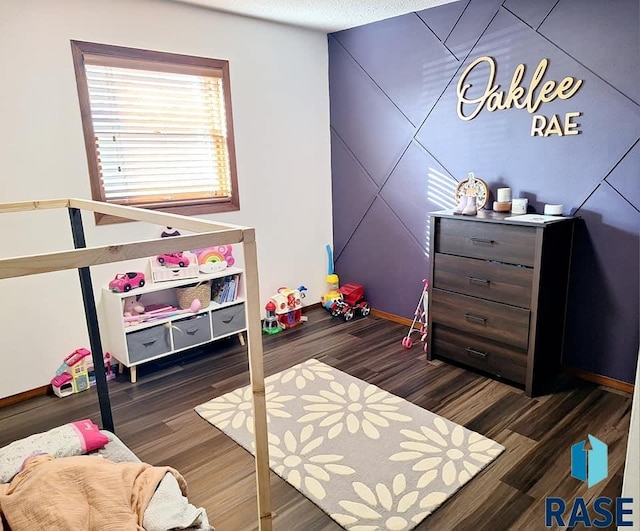 bedroom with dark hardwood / wood-style flooring and a textured ceiling