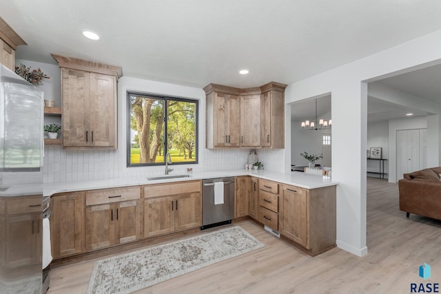 kitchen with light wood-type flooring, pendant lighting, an inviting chandelier, sink, and dishwasher