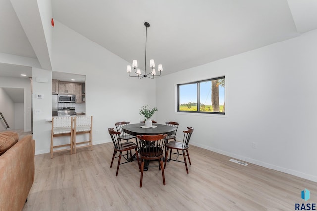 dining room with high vaulted ceiling, light hardwood / wood-style flooring, and a notable chandelier