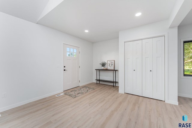 foyer entrance with light wood-type flooring and a wealth of natural light