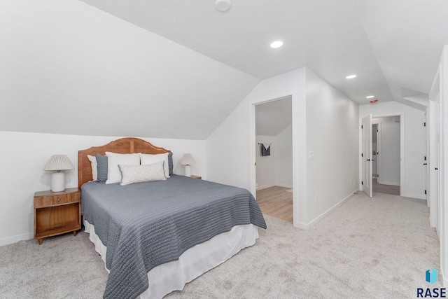 bedroom with vaulted ceiling and light carpet